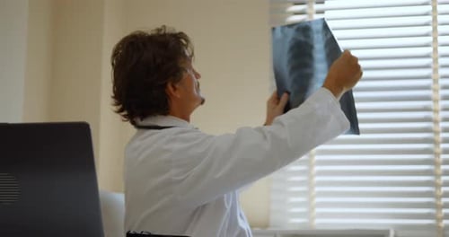 A specialist doctor is diagnosing an injury on a patient's x-ray film.