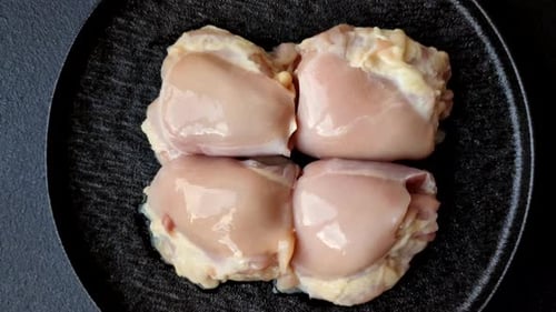 Chicken meat, raw boneless thigh fillets for grilling with salt. Raw chicken thigh fillets