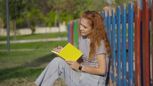 Young Woman Writes in Journal in Park Setting
