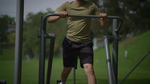 Man Working Out On Elliptical Machine in Park