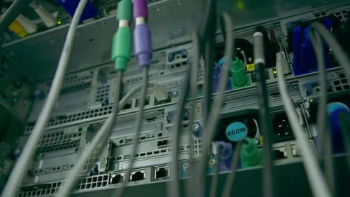 close-up of a pile of network patch cables sorted in a rack cabinet leading from a patch panel