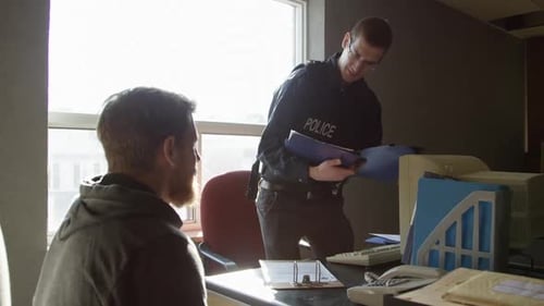 Police officer sits down with perp in precinct office HD