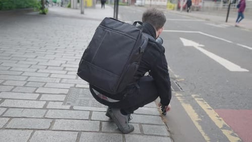 Videographer on location in a city venue filming people crossing road
