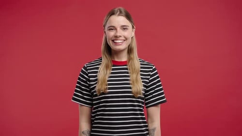 Smiling woman in striped shirt on red backdrop