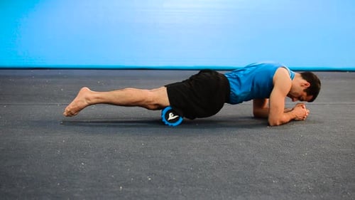 Man Uses Foam Roller for Thigh Exercise