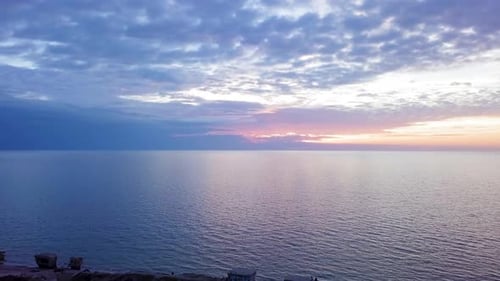 Beautiful aerial vibrant high contrast sunset over calm Baltic sea, dark storm clouds at horizon, Ka