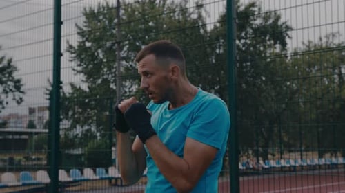 Muscular Man Shadow Boxing at an Outdoor Court
