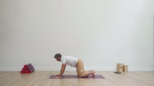 Man Practicing Yoga Poses on Mat Indoors