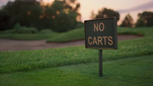 Golf Course Grass Sign in Empty Grass Fairway. Transport Restriction in Sunset