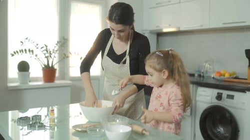 Woman and Child Baking Together in Kitchen