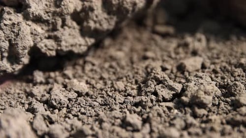 Texture of dry soil outdoors, closeup. Camera moving right