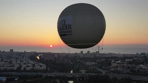 Aerial Shot Of Hot Air Balloon Descending Over Yarkon Park Against Sky In City