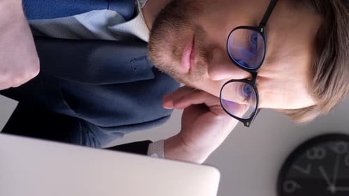 Ein junger Geschäftsmann arbeitet mit einem Laptop im Büro Vertikales Video