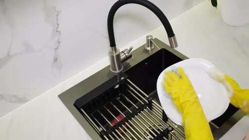 Hands Washing Plate in Kitchen Sink with Soap