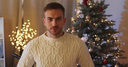 Man Smiles and Holds Christmas Gift Indoors