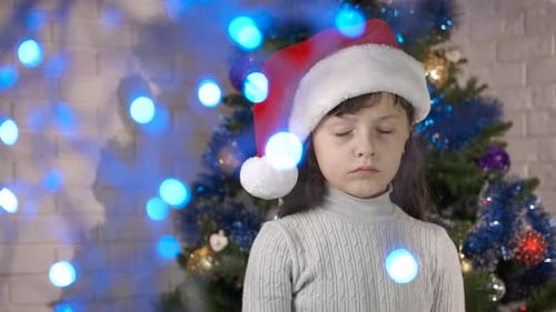 Child in Santa Hat Giving Thumbs Down