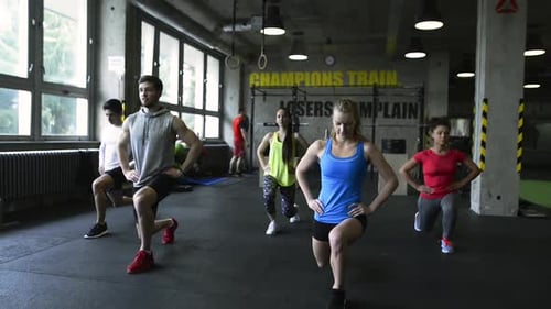 People Doing Lunges at an Indoor Gym