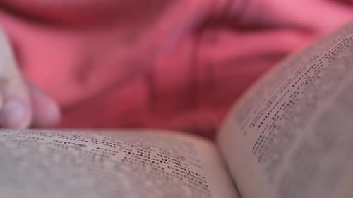 Hand Turns Pages of Worn Book in Close-up