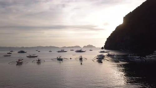 Captura aérea en 4K de barcos de pesca y excursiones en la bahía de la playa de Corong Corong en El Nido, Palawan