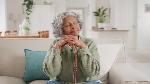 Woman Smiling and Sitting with Walking Cane Indoors