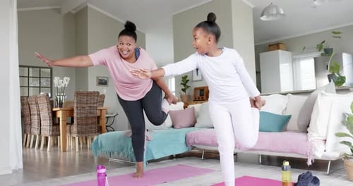 Woman and Girl Doing Yoga in Living Room