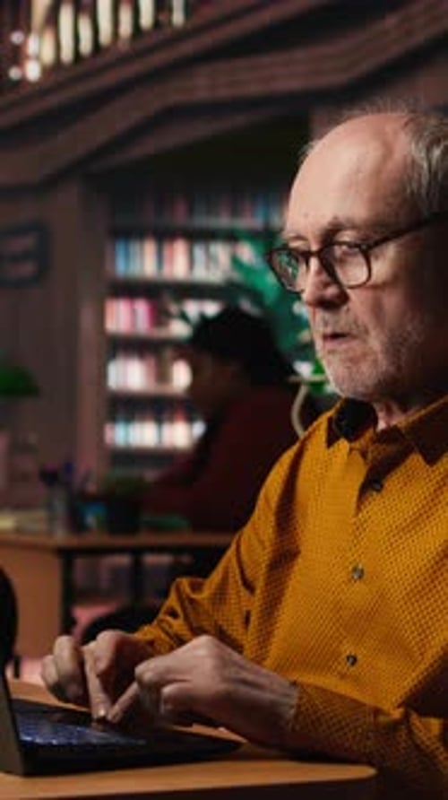 Vertical Video Aged Man Student Typing on Laptop in Campus Library for Thesis Project