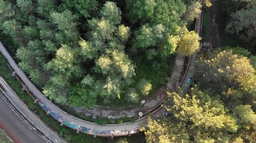 Luftaufnahme: Die olympische Bobbahn von Sarajevo auf dem Berg Trebević. Zenitale Aufnahme. Drohne geht unter