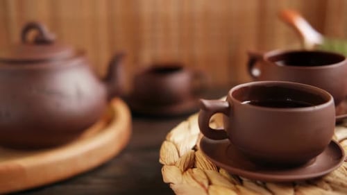 Cerimônia do chá: utensílio de chá asiático tradicional que serve uma pessoa autêntica servindo chá marrom