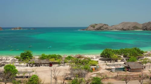 The white sand beach of Tanjung Aan in Lombok, Indonesia during a sunny day. Aerial shot.