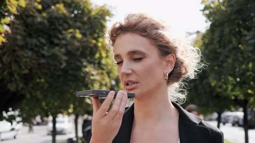 Stylish Woman Talking into Phone in City Park