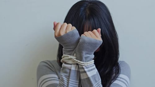 Young woman with hands tied with rope for concept of human trafficking and kidnapping