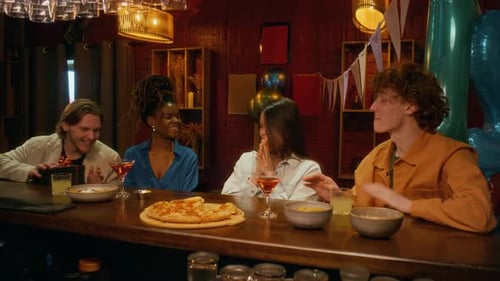 Group of Four Young Adults Celebrating Birthday, Opening Gift at Bar Counter
