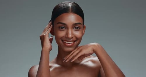 Face, skincare touch and beauty of woman in studio isolated on a gray background