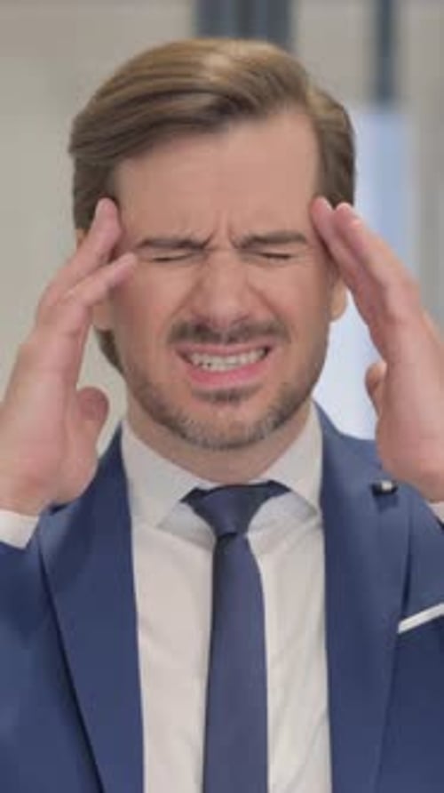 Man in Suit Massaging Temples to Relieve Headache