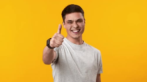 Smiling Man Giving Thumbs Up and Pointing
