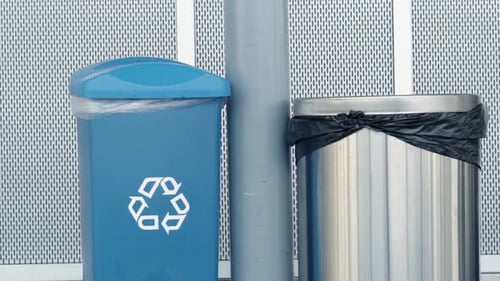 Garbage can and recycling bin side by side in building hallway