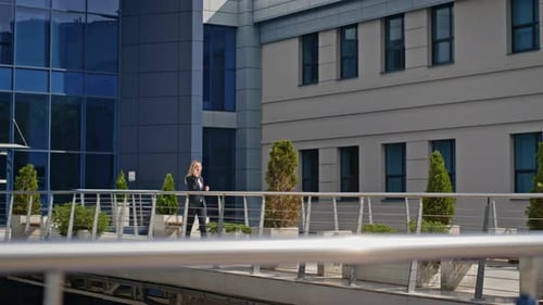 Elegant Businesswoman Walking Smartphone Near Modern Glass Office Building