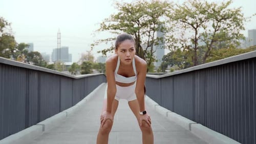 Young fitness woman in sportswear jogging in city park