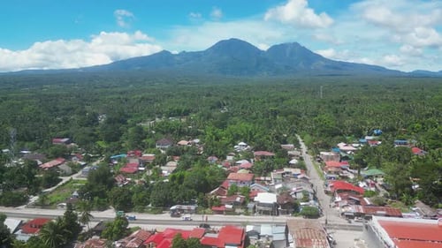Small Town with Buildings Overlooking High Mountain in Tropics