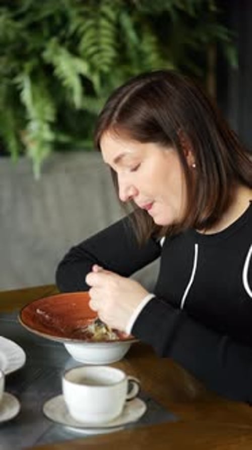 Woman Enjoying a Delicious Meal at a Cafe