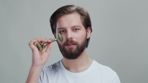 Studio Face Portrait Male Caucasian Model with Beard Massaging Skin After Cosmetic Procedures Doing