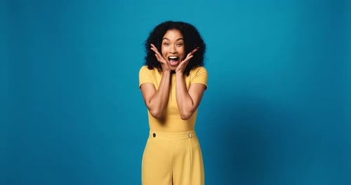 Woman, face and excited with surprise in studio, announcement or mockup space on blue background