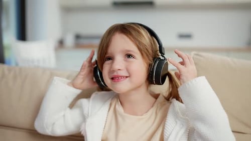 Smiling Girl Listening to Music on Headphones Indoors