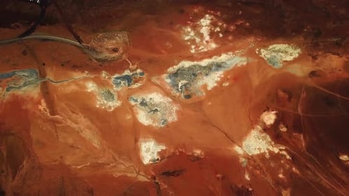 Aerial landscape view of the bright red and orange textured ground at the geothermal area of Hverir,