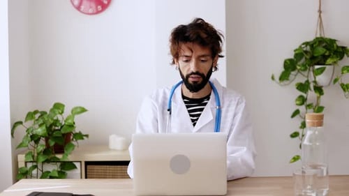 Young Doctor Using Laptop Computer in Office