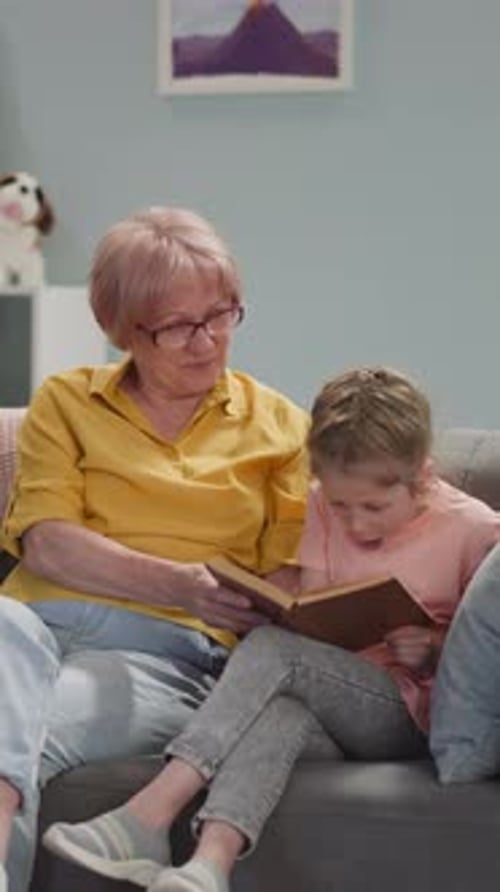 Grandmother Reads to Child on the Couch