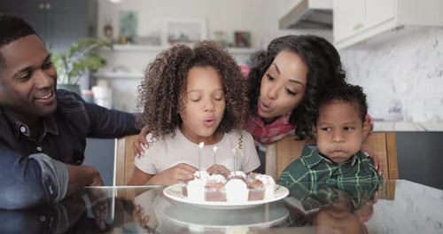 Happy Family Celebrates Child's Birthday with Cupcakes