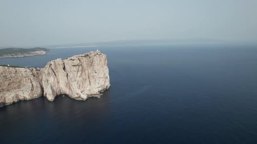 Aerial top view of a sea cliff in a blue ocean at sunset. Sea waves on beautiful landscape aerial vi