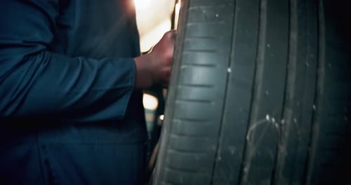 Mechanic Inspecting Tire in Workplace