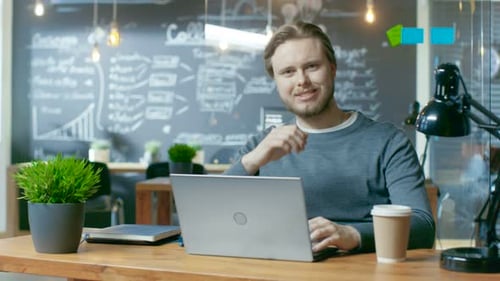 Handsome Young Office Employee Thinks on a Problem Solution While Typing on a Laptop Computer, He